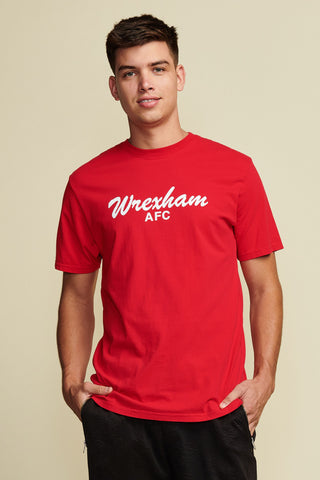 Head to waist photo of male model wearing a red men's t-shirt with "wrexham afc" written in white script font. short sleeve