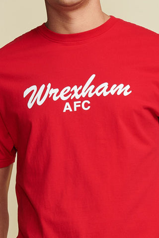Close up Photo of a male model wearing a red men's t-shirt with "wrexham afc" written in white script font. Short Sleeve