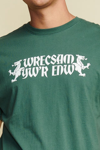 close up photo of green men's short sleeve tee with "wrecsam yw'r edw" written out which is welsh for Wrexham Is The Name, white text. White Graphic Dragons on both sides of text